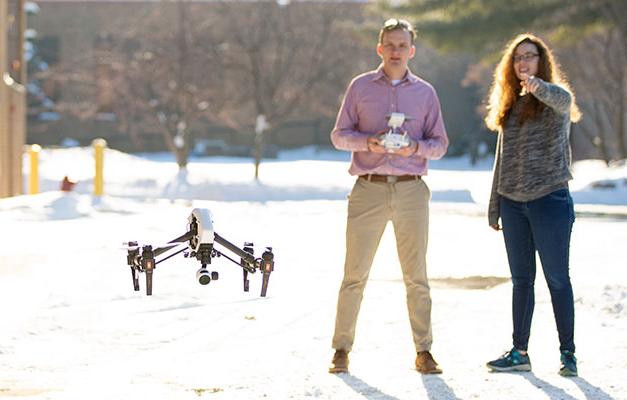 Two Students Flying a Drone in the Wintertime.